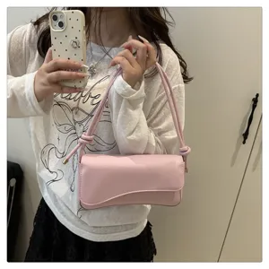 Chic pink underarm shoulder bag for women, stylish asymmetric flap design with knotted strap.