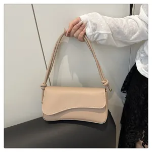 Close-up detail of the elegant beige underarm shoulder bag, showing smooth flap texture.