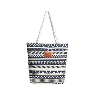 Canvas tote bag detail, blue geometric print pattern, white rope handles, casual handbag style.