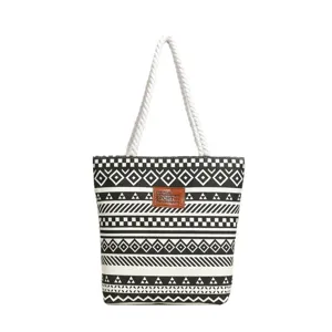 Black and white geometric canvas tote bag with thick rope handles and leather patch.