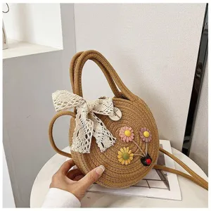 Detail shot of sweet woven round crossbody bag with cute floral decor and lace bow accent.