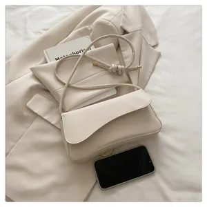 Minimalist beige shoulder bag detail, stylish underarm crossbody purse with sleek flap design.