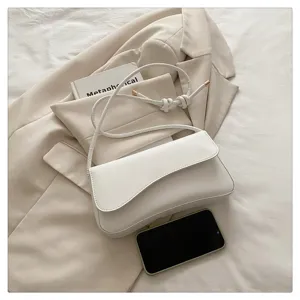 White shoulder bag detail showcasing smooth leather texture, sleek flap and stylish strap.
