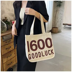 Canvas tote bag detail view, casual shoulder bag with retro 1600 letter print style.