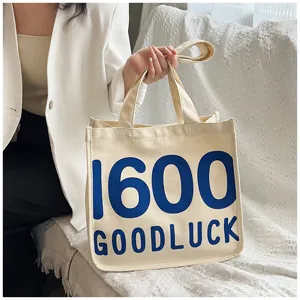 Canvas tote bag for women, stylish student shoulder bag with blue letter print and top handles.