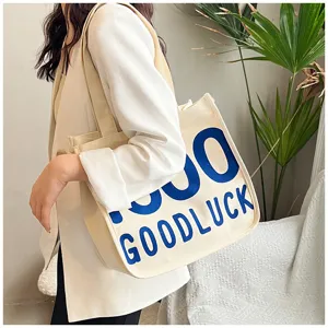Detail shot of canvas tote bag with blue text print, casual style for daily wear.