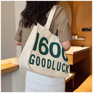 Canvas tote bag for women, stylish student shoulder bag with letter print detail.