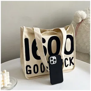 Canvas tote bag detail view, casual shoulder handbag with letter print for everyday use.