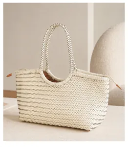 Detailed view of the handmade woven leather tote bag texture, premium cream color and dual handles.