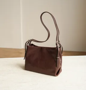 Brown leather shoulder bag detail, minimalist Korean style, elegant metal hardware.