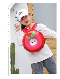 Detailaufnahme des süßen apfelförmigen Kinder-Hartschalenrucksacks am Model, leuchtend rot.