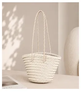 Detail shot of a French vintage white woven bucket bag featuring elegant long braided handles.