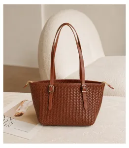 Close-up of brown woven leather tote bag detail, vintage basket style with metallic buckle.