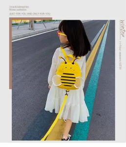 Outdoor detail shot of cute toddler anti-lost bee backpack with yellow safety leash.