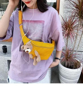 Cute yellow canvas crossbody chest bag for women, featuring a sweet plush bear pendant design.