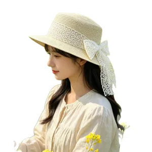 Stylish women straw hat with delicate white lace bow, perfect for beach sun protection.