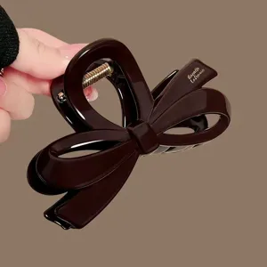 Elegante pinza de pelo con lazo marrón, gran accessorio para peinados elegantes y recogidos.