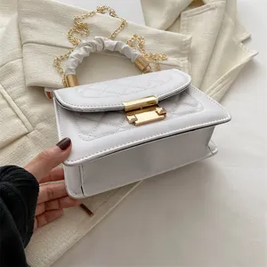 Détail de sac à main matelassé blanc avec quincaillerie dorée élégante et rabat classique.