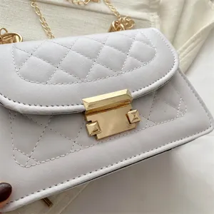 Gros plan sur le sac bandoulière matelassé blanc avec des détails dorés et chaîne.