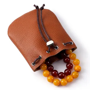 Bolsa vintage de cuero genuino con pulsera de cuentas de colores para guardar las joyas.