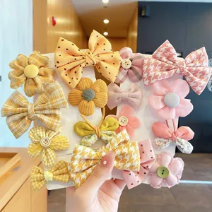 Set di graziosi fermagli per capelli da bambina con fiocchi dolci e motivi floreali colorati.