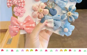 Vista dettagliata del set di mollette per capelli da bambini con fiocchi in tessuto e fiori.