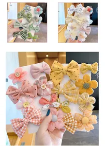 Vista dettagliata di simpatici fermagli per capelli e fiocchi per bambini con fiori in tessuto.