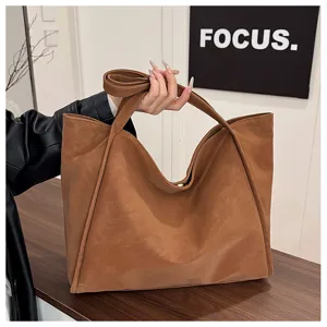 Detail shot of the brown vintage leather tote bag showcasing its soft texture and large capacity.