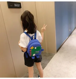 Vue détaillée du joli sac à dos enfant dinosaure de dessin animé dans le couloir.