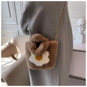 Chic plush shoulder bag detail, fluffy brown winter handbag with cute fried egg pattern.