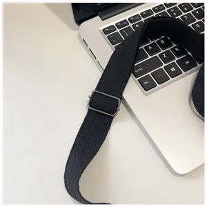 Bag shoulder strap detail, adjustable metal buckle, durable black fabric strap accessory.