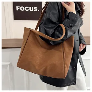 Detail shot of brown PU leather tote bag worn on shoulder, casual daily commuting style.