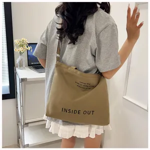Retro canvas shoulder bag for women, large capacity casual crossbody tote bag with text print.