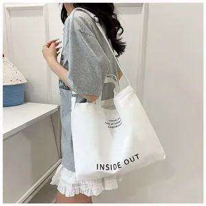 Detailed view of the white canvas tote bag, featuring print design and large capacity for daily use.