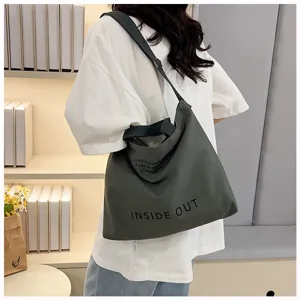 Detailed view of the dark green canvas tote bag showcasing texture and printed letters.