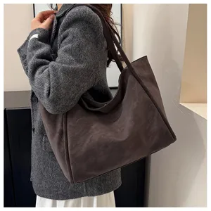 Minimalist brown tote bag detail showing soft leather texture and stylish shoulder wear.