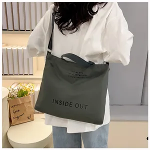 Detailed view of the dark grey canvas tote bag with shoulder strap and stylish print.