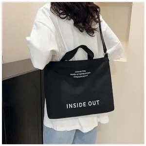 Black canvas tote bag detail view, large capacity shoulder bag for daily casual use.
