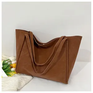 Close-up detail of brown PU leather tote bag with large capacity and double straps for daily use.