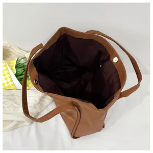 Brown faux leather tote bag interior detail, spacious shoulder bag for daily work commute.