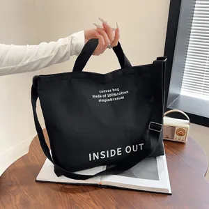 Black canvas tote bag for women, large capacity shoulder and crossbody bag with dual handles.