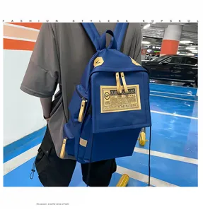 Detailed view of the blue travel backpack with contrast buckles worn in a parking lot scene.