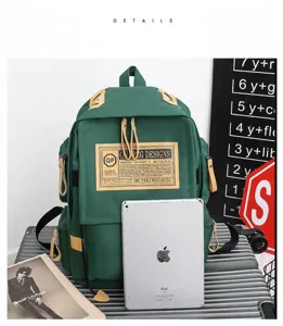 Green oxford cloth backpack detail showing large capacity, multiple pockets and durable zippers.