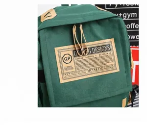 Green Oxford cloth backpack detail showing brown leather zipper pulls and vintage brand patch.