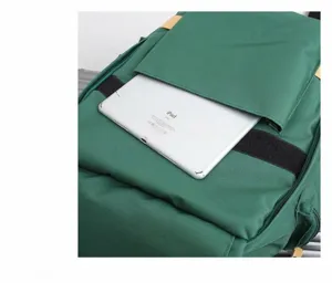 Green oxford cloth backpack detail showing large capacity and laptop compartment storage.