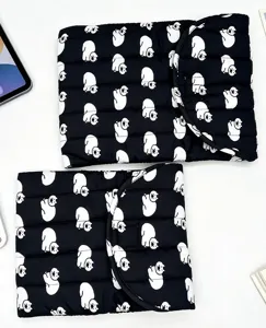 Detailed view of black quilted laptop sleeve featuring cute white cat pattern and neat stitching.