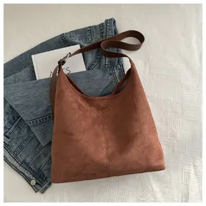 Λεπτομέρεια τσάντας ώμου από καφέ σουέτ, vintage hobo σχέδιο με καφέ λουράκι, casual στιλ.