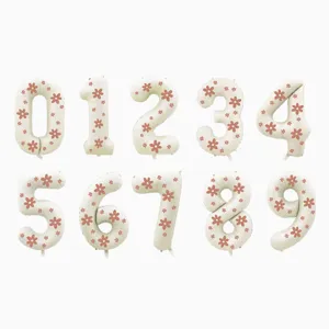 Detailed view of cream number balloons featuring pink floral patterns for birthday party decor.