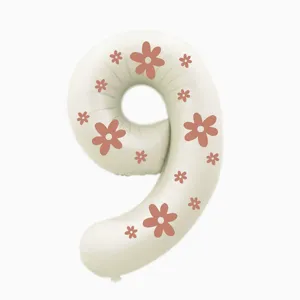 Close-up of cream number 9 balloon with pink floral pattern, ideal for birthday party decor.
