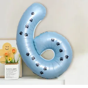 Close-up of blue number 6 foil balloon with cute black paw prints for party scene setup.